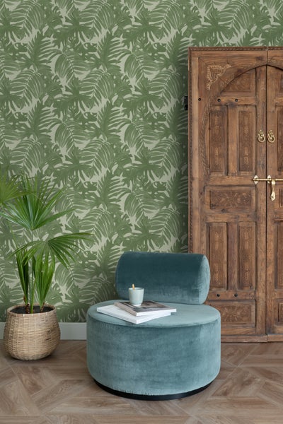 Dekorativer Raum mit grüner Blättertapete, Holztür und blaugrünem Sessel