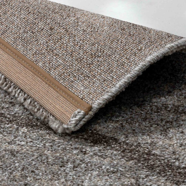 Teppich mit melierter Textur, umgeschlagene Ecke zeigt den gewebten Rücken und die gekettelte Kante.