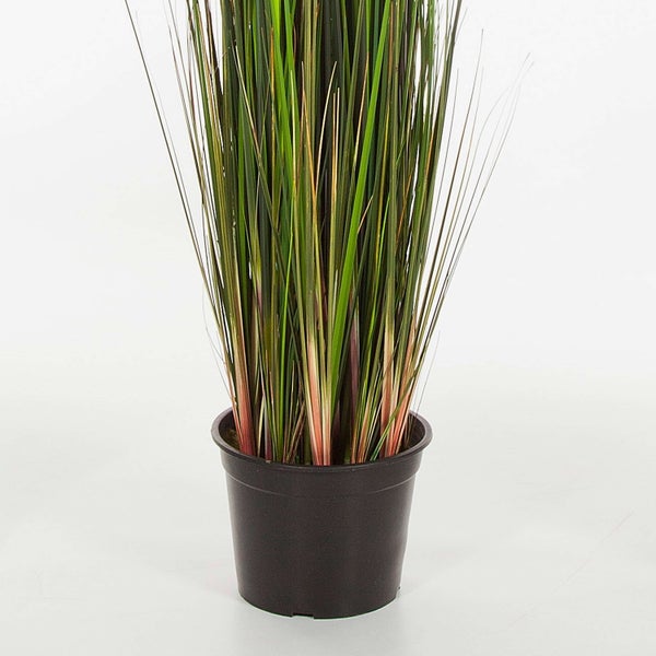 Künstliches Ziergras mit langen, schmalen Halmen in einem schwarzen Kunststofftopf.