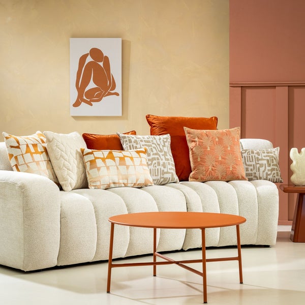 Wohnzimmer mit Sofa, Zierkissen und Beistelltisch