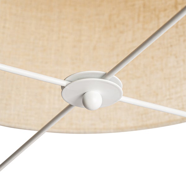 Detail eines weißen Metallgestells für Lampenschirme mit zentraler Befestigung vor einem beigefarbenen Textilschirm.