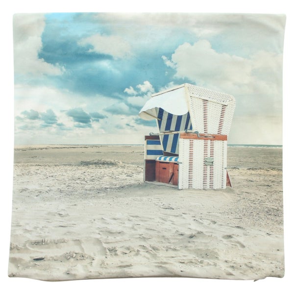 Quadratische Kissenhülle mit Fotodruck eines Strandkorbs am Sandstrand unter einem bewölkten Himmel.