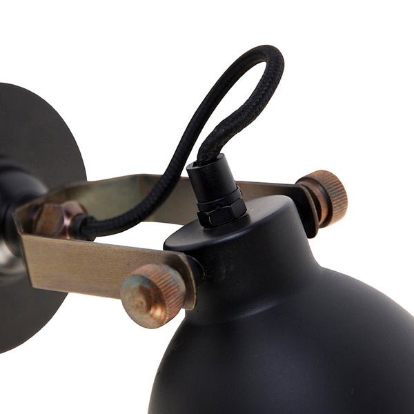 Detailansicht einer schwarzen Wandleuchte mit Textilkabel