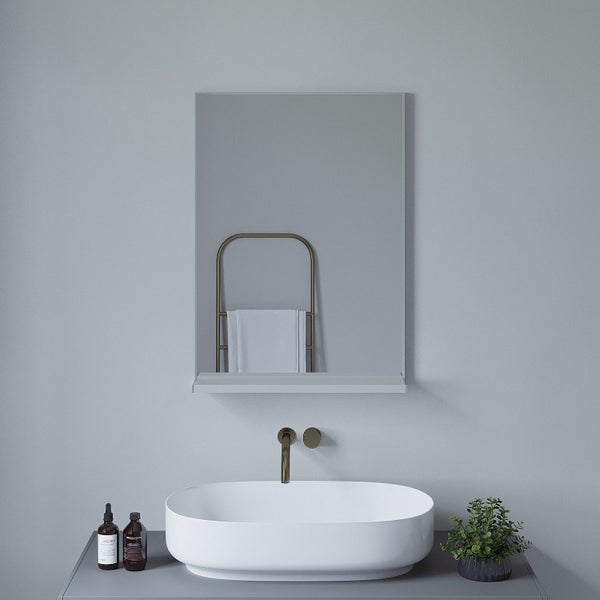 Badezimmer mit ovalem Aufsatzwaschbecken, wandmontierter Armatur, Spiegel mit Ablage und Handtuchhalter an der Wand.