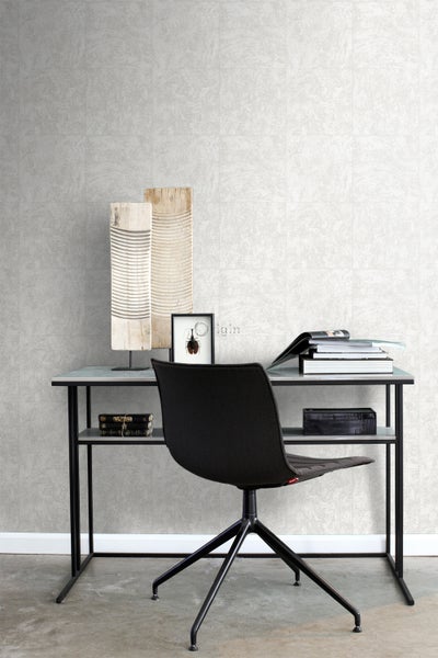 Schreibtisch mit Stuhl vor einer Wand mit Fliesen in Steinoptik