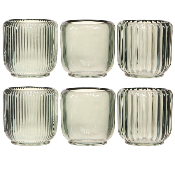 Sechs Teelichthalter aus Glas, vier mit Rillenstruktur und zwei mit glatter Oberfläche.