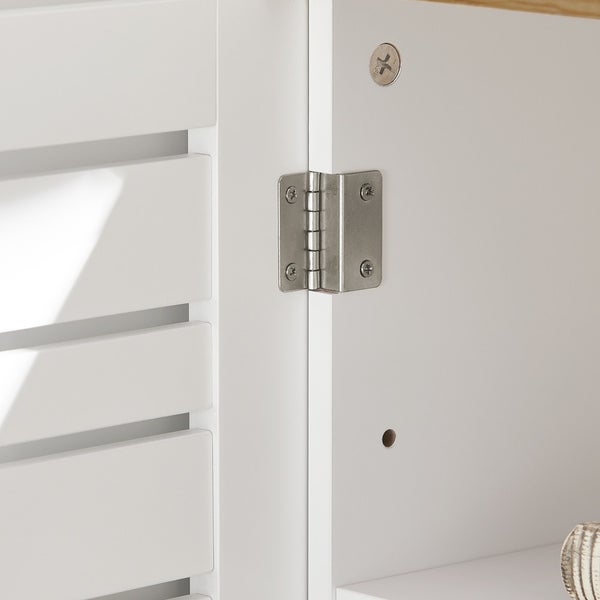 Detailansicht eines weißen Möbels mit Lamellentür und einem Scharnier aus Metall.