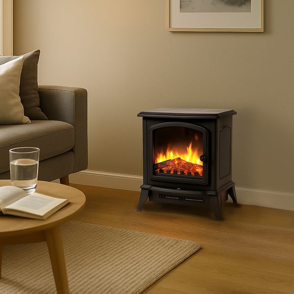 Freistehender Elektrokamin in Ofenoptik mit künstlichem Flammeneffekt in einem hellen Wohnzimmer neben einem Sofa und Couchtisch auf Holzboden.