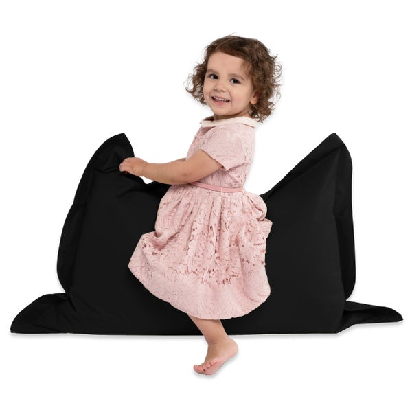 Mädchen steht auf einem schwarzen Sitzsack