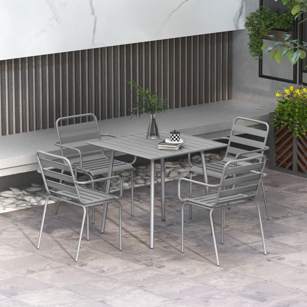 Modernes Gartenmöbel-Set mit quadratischem Metall-Lamellentisch und vier Armlehnenstühlen auf einer Terrasse mit Steinplatten und Holzwand.