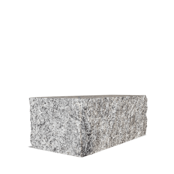 Mauerstein aus Granit mit gespaltener Oberfläche und gesprenkelter Textur.