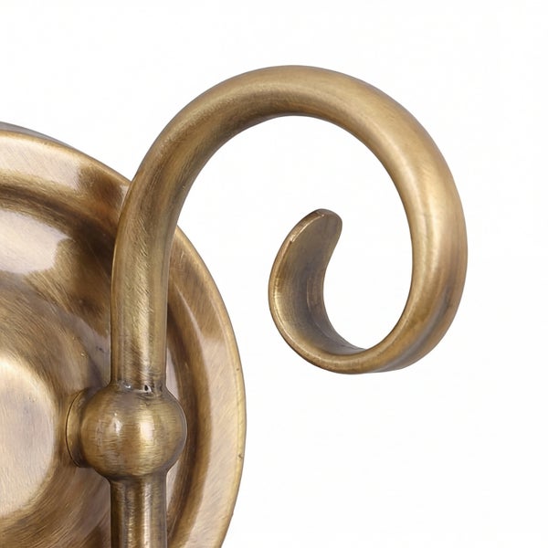 Detailaufnahme einer Wandleuchte aus Metall mit geschwungenem Arm