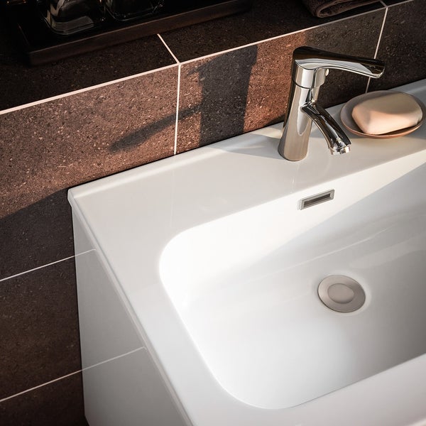 Detailansicht eines weißen Keramikwaschbeckens mit Armatur im Badezimmer