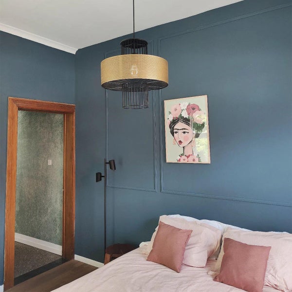 Schlafzimmer mit Deckenlampe, Bett und Dekorationsbild an der Wand