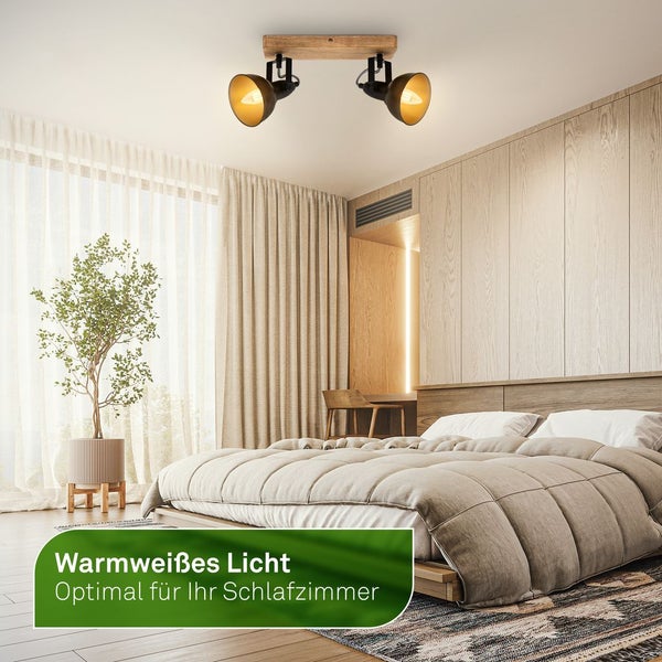Zweiflammige Deckenleuchte aus Holz und Metall in einem hellen, modernen Schlafzimmer mit Doppelbett und Holzverkleidung für warmweißes Licht.