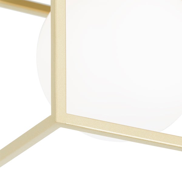 Nahaufnahme einer modernen Leuchte mit goldfarbenem geometrischem Metallrahmen und weißer Glaskugel.