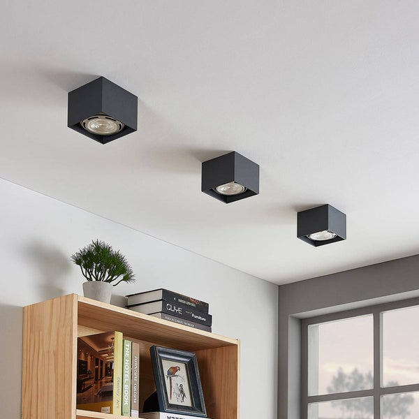 Drei schwarze, würfelförmige Deckenleuchten an einer weißen Decke