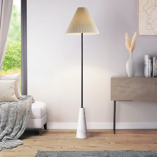 Stehlampe mit plissiertem Schirm und Marmorfuß in einem Wohnzimmer.