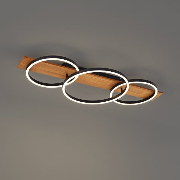 LED Deckenleuchte mit drei ringförmigen Elementen und Holzelement für ein modernes Design.