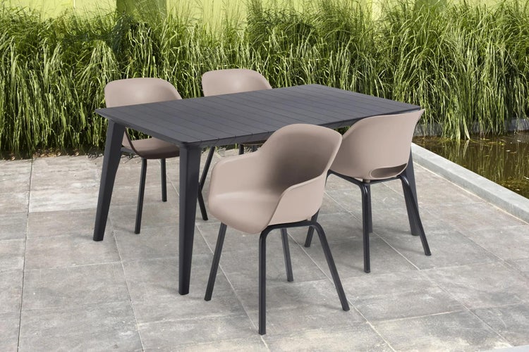 Moderne Gartengarnitur mit dunklem Tisch und vier beigen Schalenstühlen aus Kunststoff und Metall auf einer Steinterrasse.