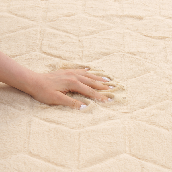 Hand auf einem flauschigen Teppich mit geometrischem Steppmuster für ein weiches Gefühl