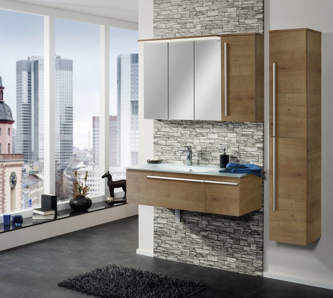 Modernes Badezimmermöbel-Set in Eichenoptik mit Waschtischunterschrank, Waschbecken, Spiegelschrank und Hochschrank in einem hellen Badezimmer.