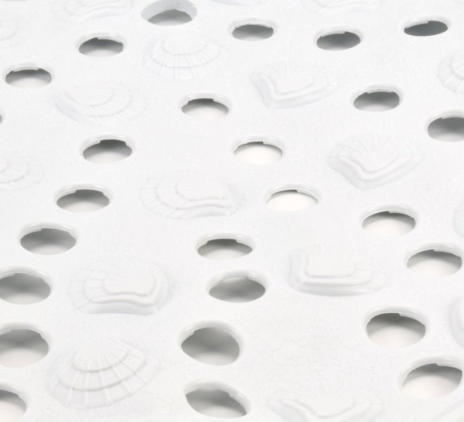 Detailansicht einer Badewannenmatte mit Muschelmuster und Löchern zur Wasserableitung