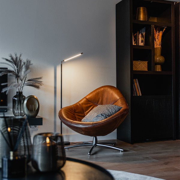 Leseecke mit Sessel, Stehleuchte und Bücherregal im Wohnzimmer.