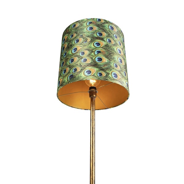 Zylindrischer Lampenschirm aus Textil mit Pfauenfedermuster auf einem goldfarbenen Lampenstativ.