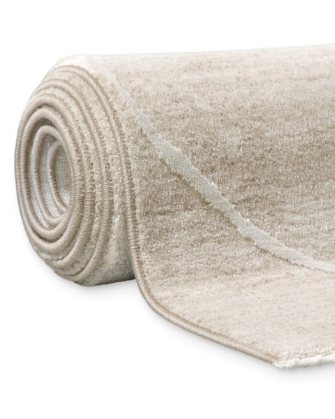 Eingerollter Teppich mit weichem Flor und dezentem Linienmuster.
