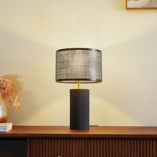 Dekorative Tischleuchte mit Lampenschirm auf einem Holzschrank