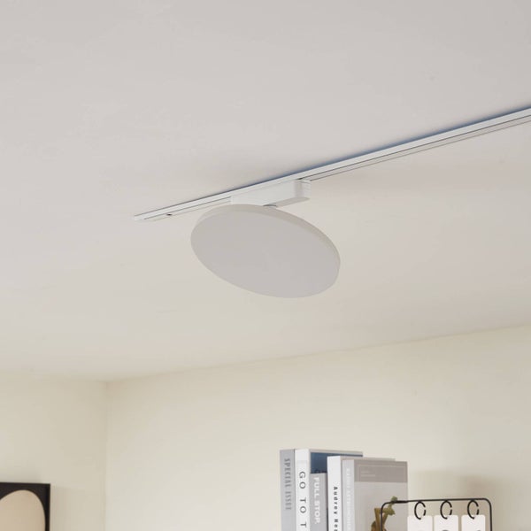 Runde, flache LED-Schienenleuchte an einem weißen Schienensystem an der Decke montiert.