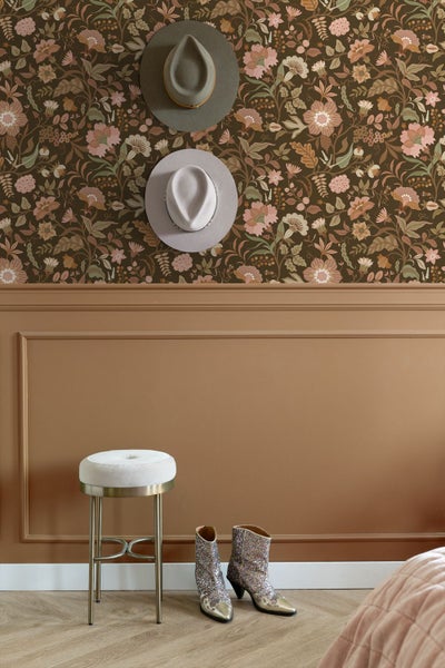 Schlafzimmer mit floral gemusterter Vliestapete, gepolstertem Bettkopfteil, Nachttisch und Textilien.