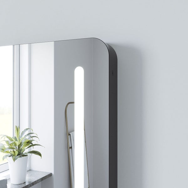 Wandspiegel mit abgerundeten Ecken und vertikaler LED Beleuchtung integriert in einem Badezimmer