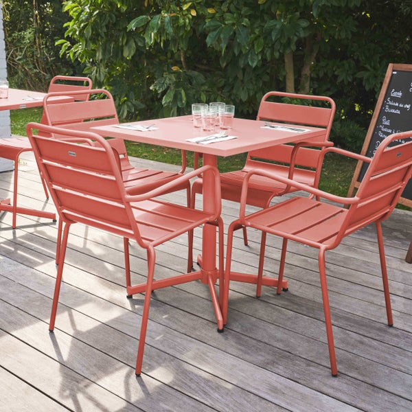 Modernes Gartenmöbel-Set aus Metall mit quadratischem Tisch und vier Stühlen auf einer Holzterrasse, eingedeckt mit Gläsern und Besteck.