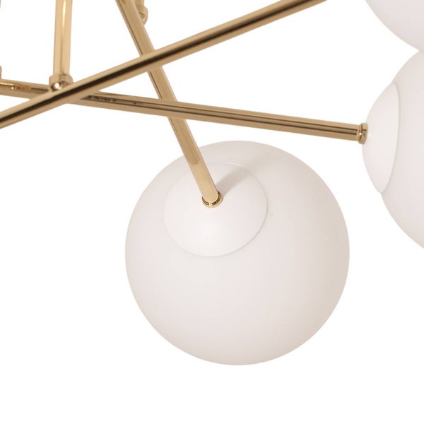 Detailaufnahme einer Deckenleuchte mit goldenem Gestell und weißen Kugellampenschirmen.