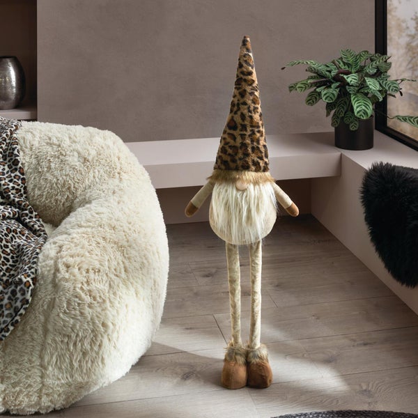Dekorative Wichtelfigur mit langen Beinen und spitzer Mütze im Leopardenmuster als Weihnachtsdeko im Wohnzimmer