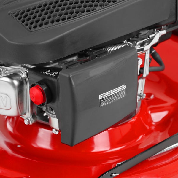 Nahaufnahme eines Rasenmähermotors mit rotem Primer-Knopf und schwarzem Luftfiltergehäuse.