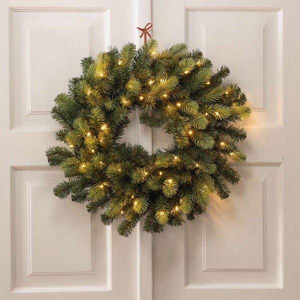 Weihnachtlicher Tannenkranz mit Beleuchtung an einer Tür