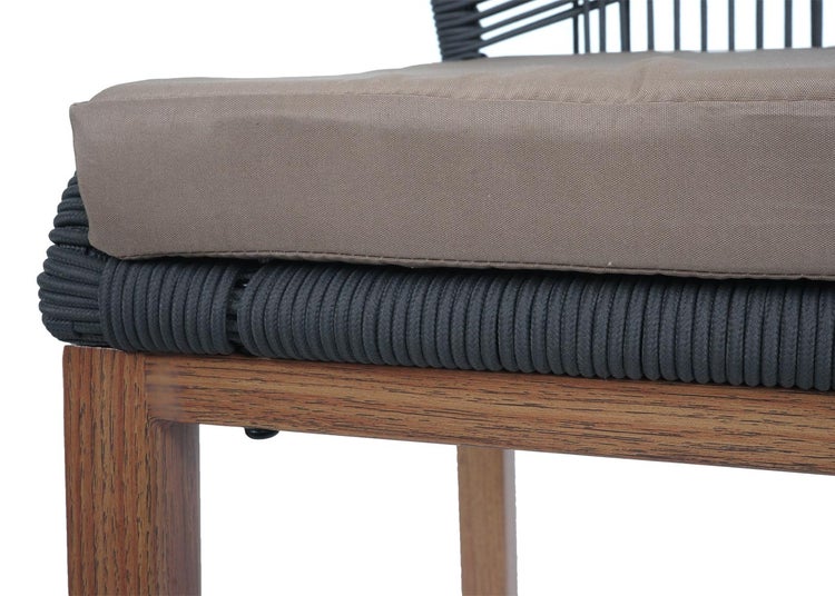 Detailansicht eines Stuhls mit Kordelbespannung, Holzbett und Kissen