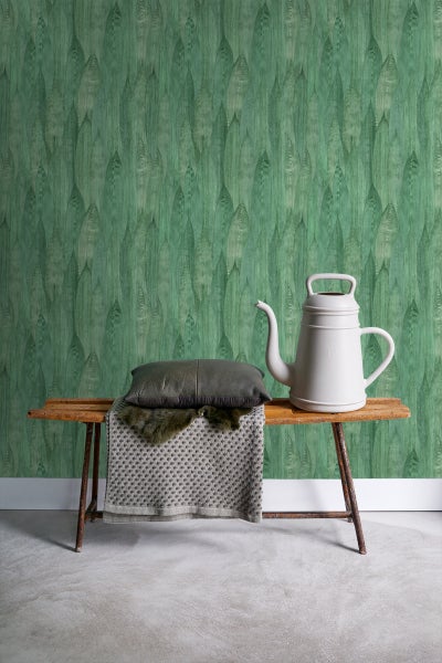 Gestaltungsidee mit Bank, Kissen, Decke, Gießkanne und gemusterter Tapete