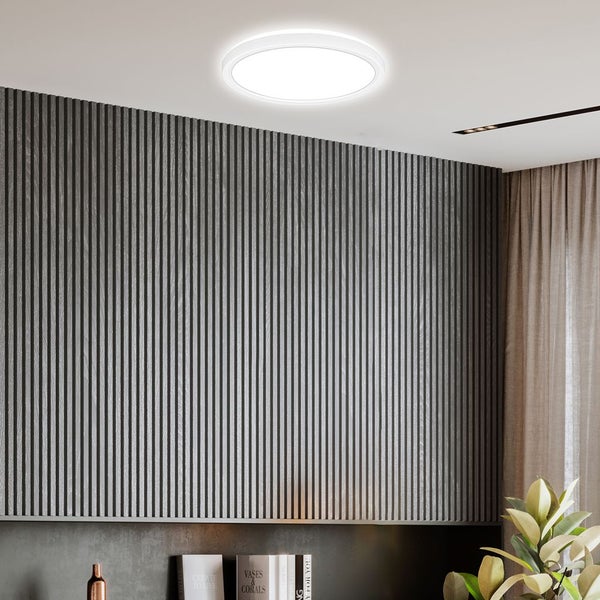 Runde LED-Deckenleuchte in einem modern gestalteten Raum mit dunkelgrauer Wandverkleidung aus vertikalen Lamellen.