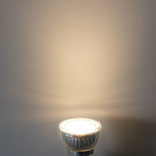 GU10 LED Reflektorlampe mit warmweißem Lichtkegel an einer Wand.