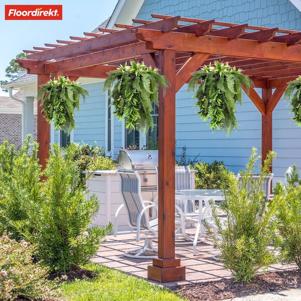 Floordirekt Logo. Garten mit Holzpergola und hängenden Farnen. Enthält weiße Gartenmöbel, einen Grill und blaue Hauswand. Hell und organisiert.