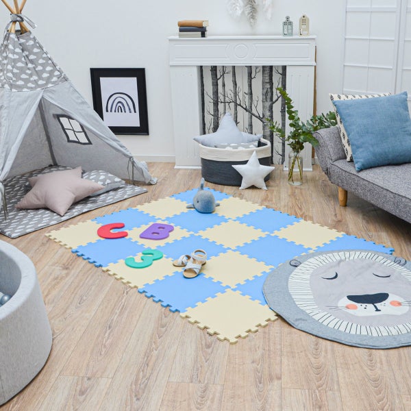 Helles Kinderzimmer mit blau-beiger Schaumstoff-Puzzlematte, Tipi-Zelt mit Wolkenmuster und rundem Spielteppich mit Löwenmotiv auf Holzboden.