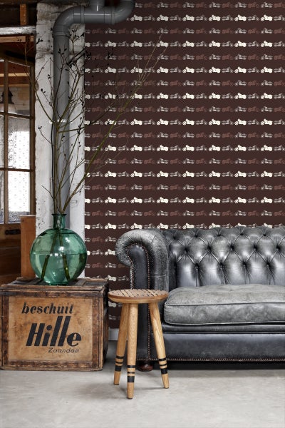 Wohnzimmer mit Tapete mit Motorradmuster, einem Holzhocker und einer Ledercouch