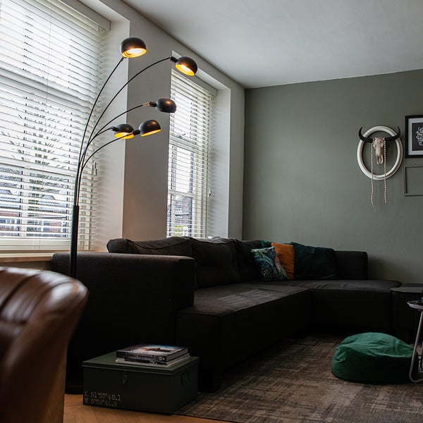 Wohnzimmer mit Sofa, Stehlampe und Dekorationen