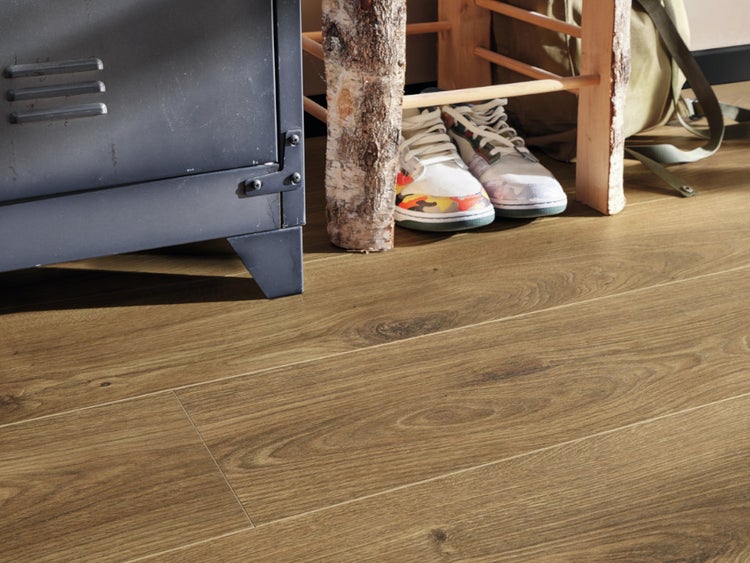 Holzoptik Laminatboden in Eiche mit ausgeprägter Maserung in einem modern eingerichteten Raum mit Metallschrank und rustikalem Holzhocker.