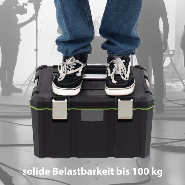 Eine Person steht auf einer schwarzen Werkzeugkiste, die eine solide Belastbarkeit bis 100 Kilogramm aufweist.