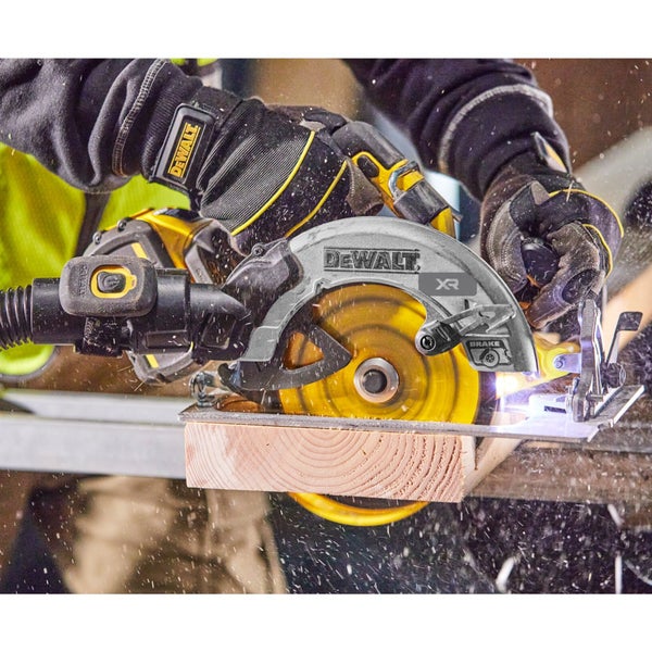 Eine Hand mit Handschuhen führt eine DeWalt Handkreissäge beim Sägen von Holz, wobei Sägespäne und Funken fliegen.